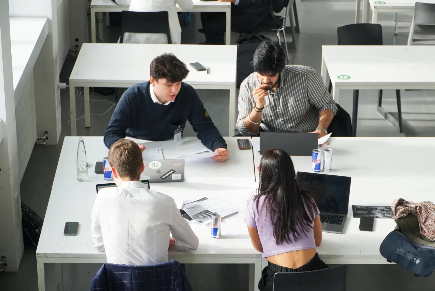Ein Studierendenteam arbeitet gemeinsam an Laptops